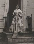 Black and white photo of Grandma standing on the steps of MacArthur House at GCVM.